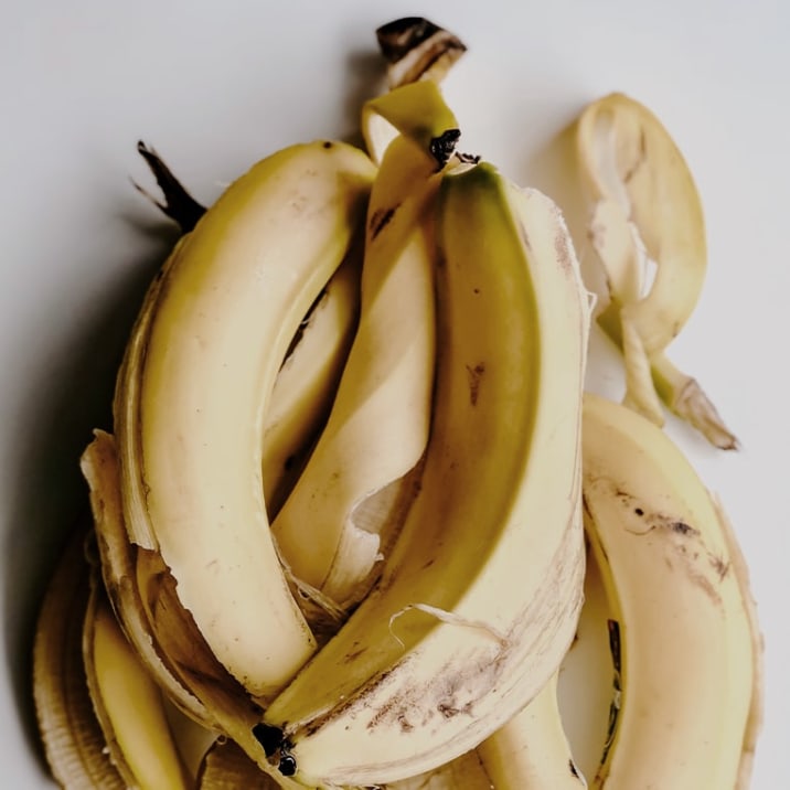 Banana peels on a table that are turing brown