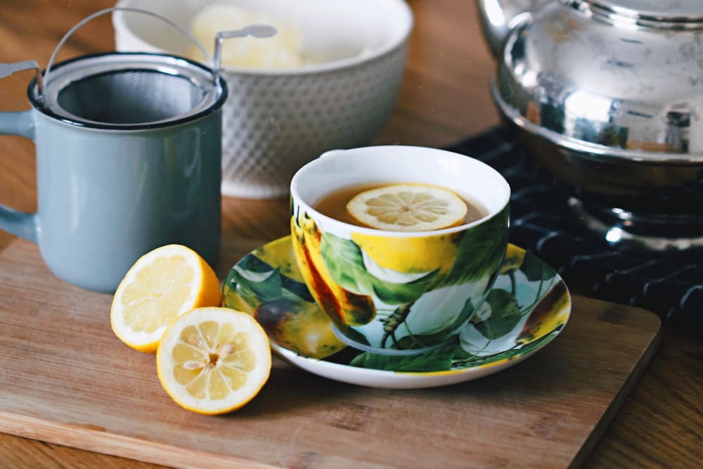 A cup of hot water with slices of lemon in it