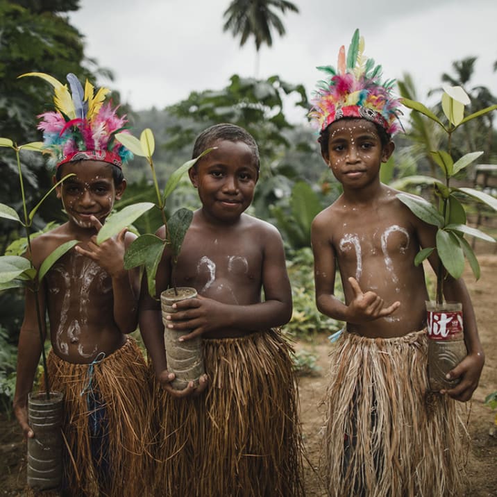 Three children holding trees in Indonesia