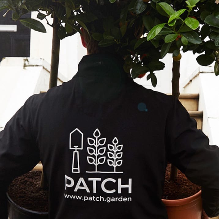 A member of the Patch team carrying plants